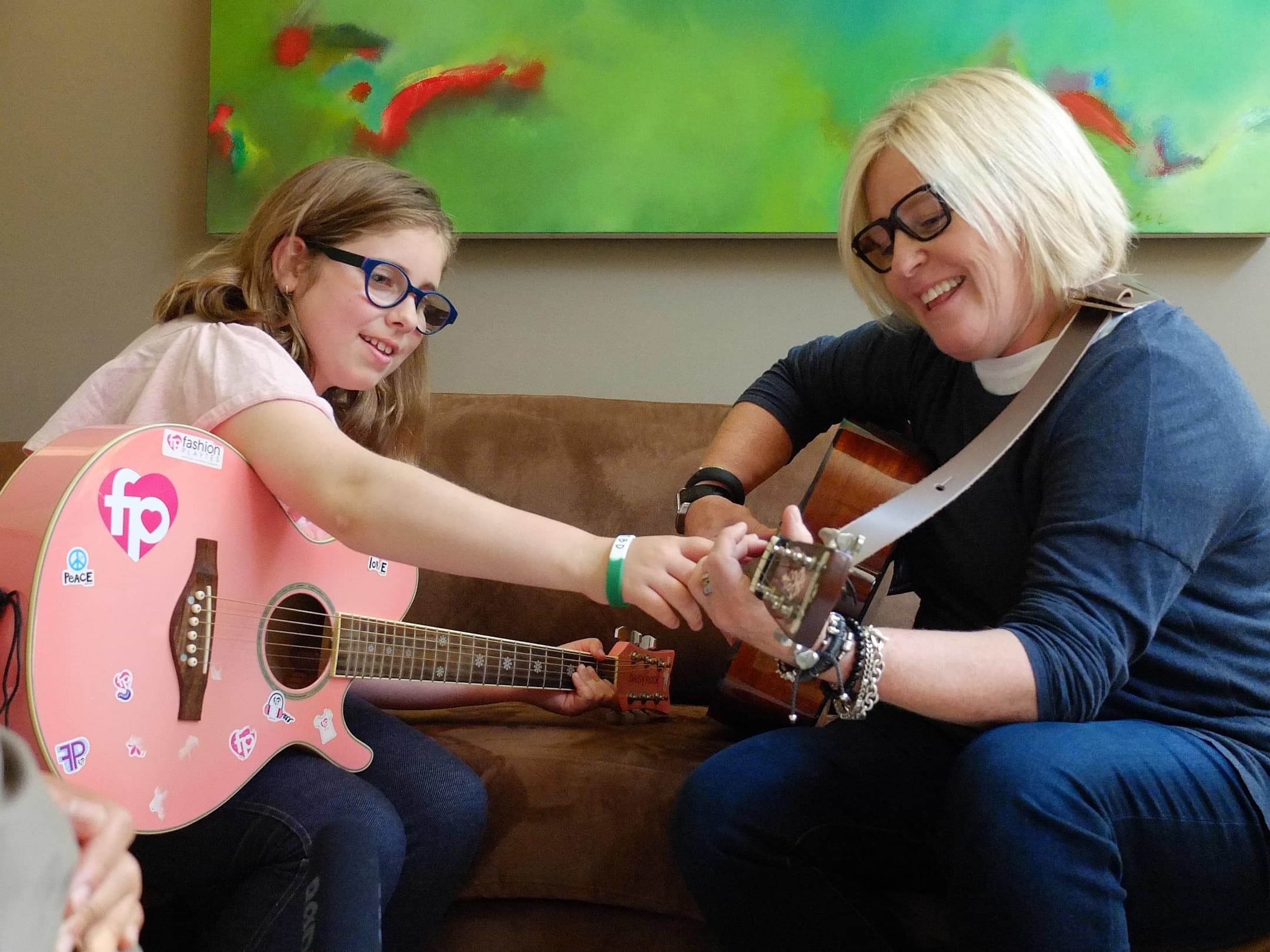 Amy Errett and her daughter Madison Reed playing guitar together